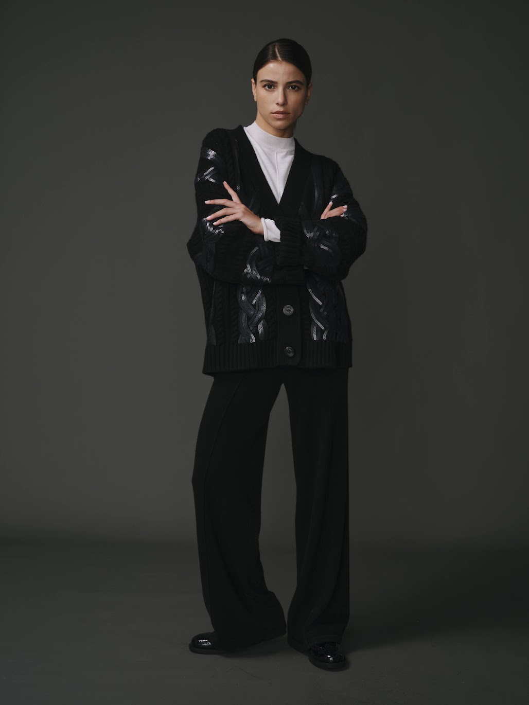 Cardigan tressé noir pour femme en 100% laine, avec un design texturé et élégant.