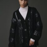 Cardigan tressé noir pour femme en 100% laine, avec un design texturé et élégant.
