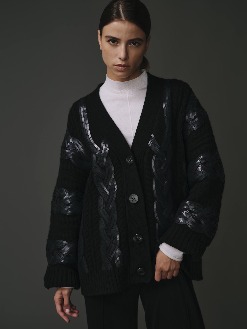 Cardigan tressé noir pour femme en 100% laine, avec un design texturé et élégant.