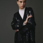 Cardigan tressé noir pour femme en 100% laine, avec un design texturé et élégant.
